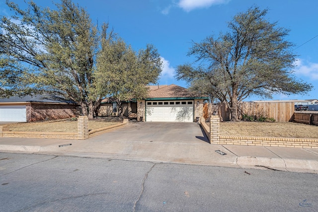 single story home featuring a garage, brick siding, concrete driveway, and fence