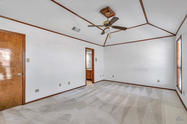 unfurnished room with visible vents, lofted ceiling, ceiling fan, light carpet, and crown molding