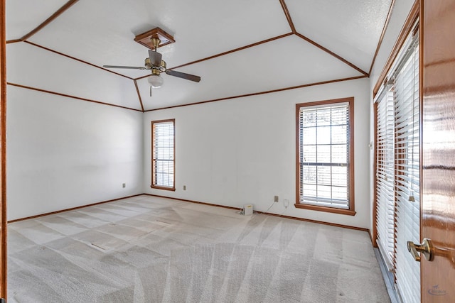 spare room with a wealth of natural light, carpet floors, ornamental molding, and vaulted ceiling