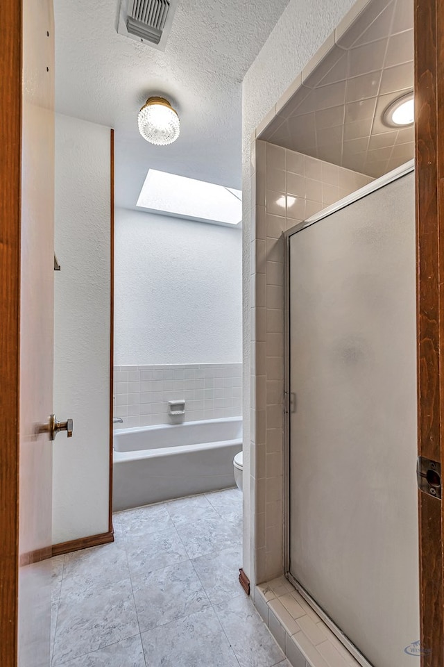 full bath with visible vents, a shower stall, toilet, a bath, and a textured ceiling