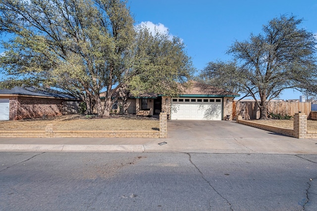 view of front of house featuring a garage, brick siding, concrete driveway, and fence