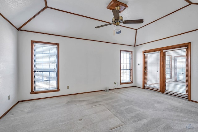 spare room with baseboards, carpet floors, lofted ceiling, ceiling fan, and ornamental molding