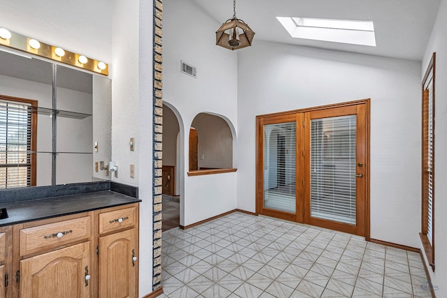 bathroom with tile patterned floors, visible vents, baseboards, and vaulted ceiling