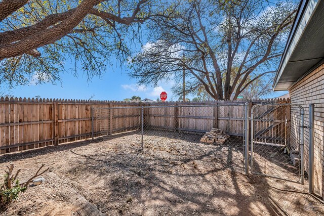 view of yard featuring a fenced backyard and a gate