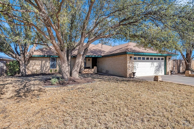 single story home featuring fence, an attached garage, concrete driveway, a front lawn, and brick siding