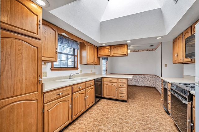 kitchen featuring light countertops, a peninsula, a textured ceiling, stainless steel appliances, and a sink