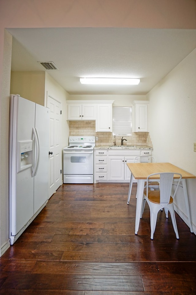 kitchen with white appliances, dark wood-style flooring, backsplash, white cabinetry, and a sink