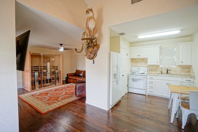 kitchen with white appliances, a sink, dark wood-type flooring, and white cabinetry