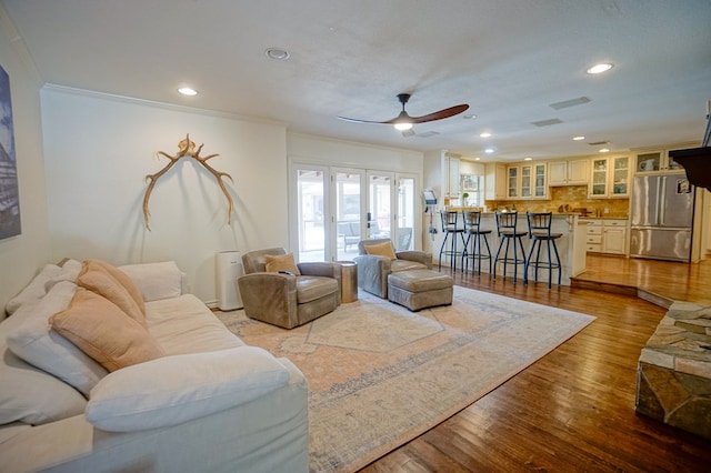 living area featuring ceiling fan, ornamental molding, recessed lighting, and wood finished floors