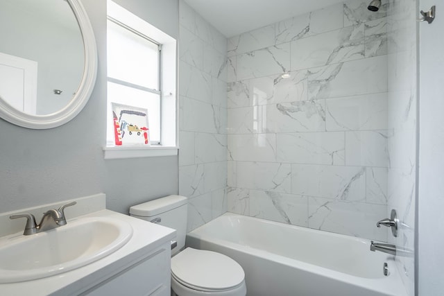 full bathroom featuring vanity, tiled shower / bath combo, and toilet