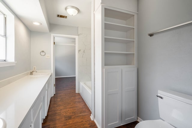 bathroom featuring vanity, wood-type flooring, and toilet