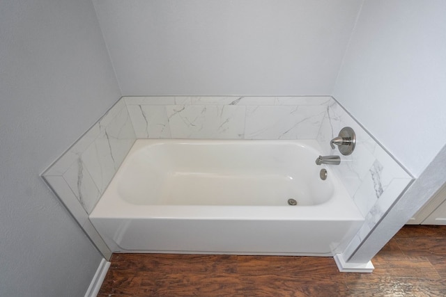 bathroom with a bathing tub and hardwood / wood-style flooring