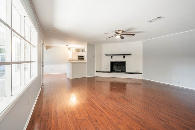 unfurnished living room featuring ceiling fan and dark hardwood / wood-style flooring