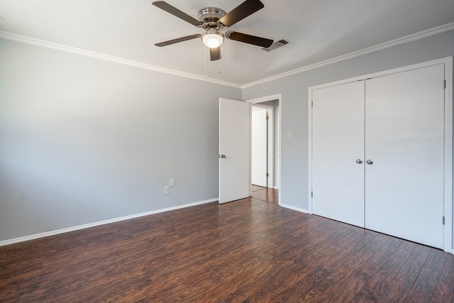 unfurnished bedroom featuring ceiling fan, ornamental molding, dark wood-type flooring, and a closet