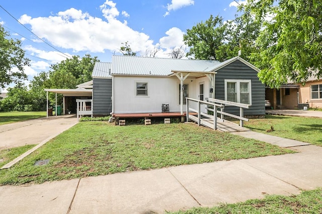 605 W Walnut St, Coleman, TX 76834 - view of front of home featuring driveway, a front yard, metal roof, and an attached carport