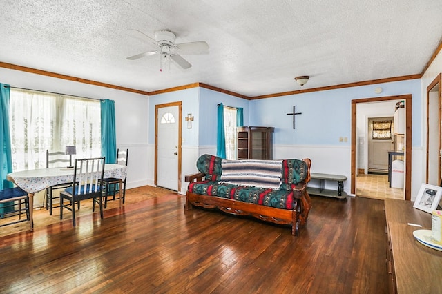 605 W Walnut St, Coleman, TX 76834 - living area with a textured ceiling, wood-type flooring, a ceiling fan, a wainscoted wall, and ornamental molding