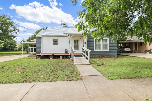 605 W Walnut St, Coleman, TX 76834 - view of front of home with metal roof, a front lawn, driveway, and a carport