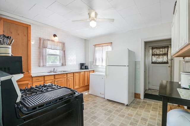 605 W Walnut St, Coleman, TX 76834 - kitchen featuring freestanding refrigerator, a ceiling fan, black range, a sink, and light flooring