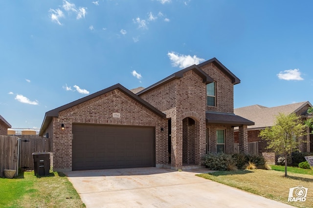 view of front of house featuring fence, a front lawn, brick siding, a garage, and driveway