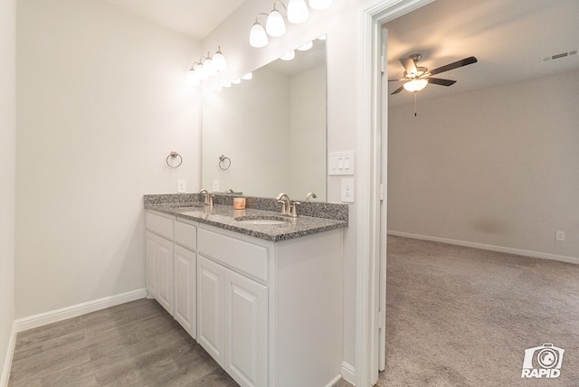 bathroom featuring visible vents, a sink, a ceiling fan, and double vanity