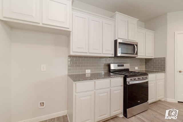 kitchen featuring white cabinets, light stone countertops, appliances with stainless steel finishes, light wood-style floors, and tasteful backsplash