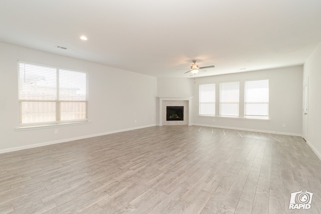 unfurnished living room featuring ceiling fan, visible vents, baseboards, and light wood-type flooring
