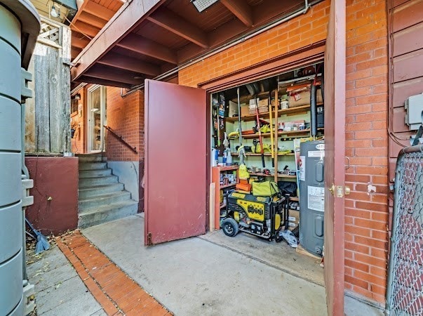 basement with water heater and brick wall