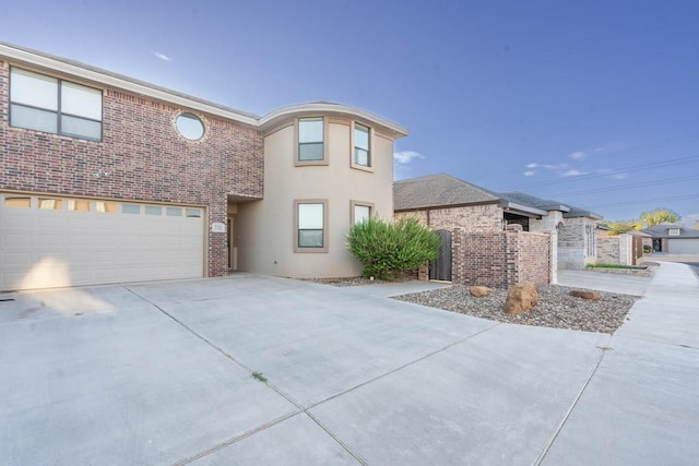traditional-style home featuring concrete driveway, brick siding, and an attached garage