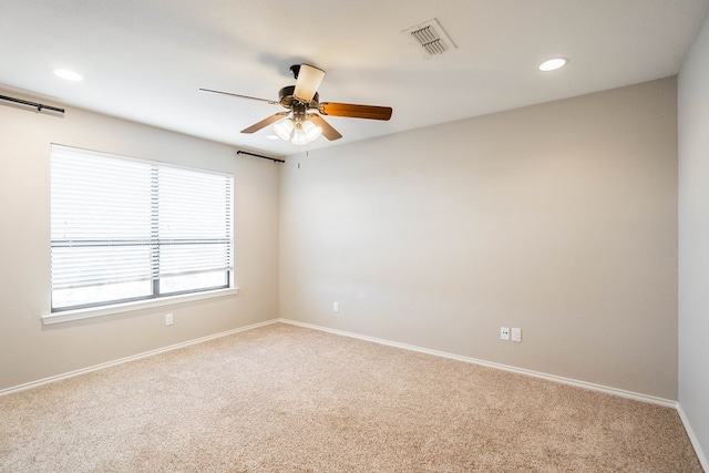 carpeted empty room featuring recessed lighting, a ceiling fan, visible vents, and baseboards