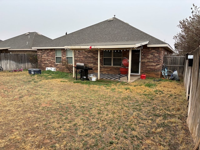 back of house featuring a patio and a yard