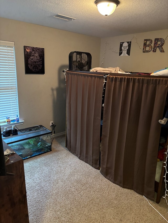 bedroom with carpet floors and a textured ceiling