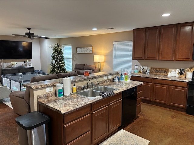 kitchen with black appliances, an island with sink, sink, ceiling fan, and dark brown cabinetry