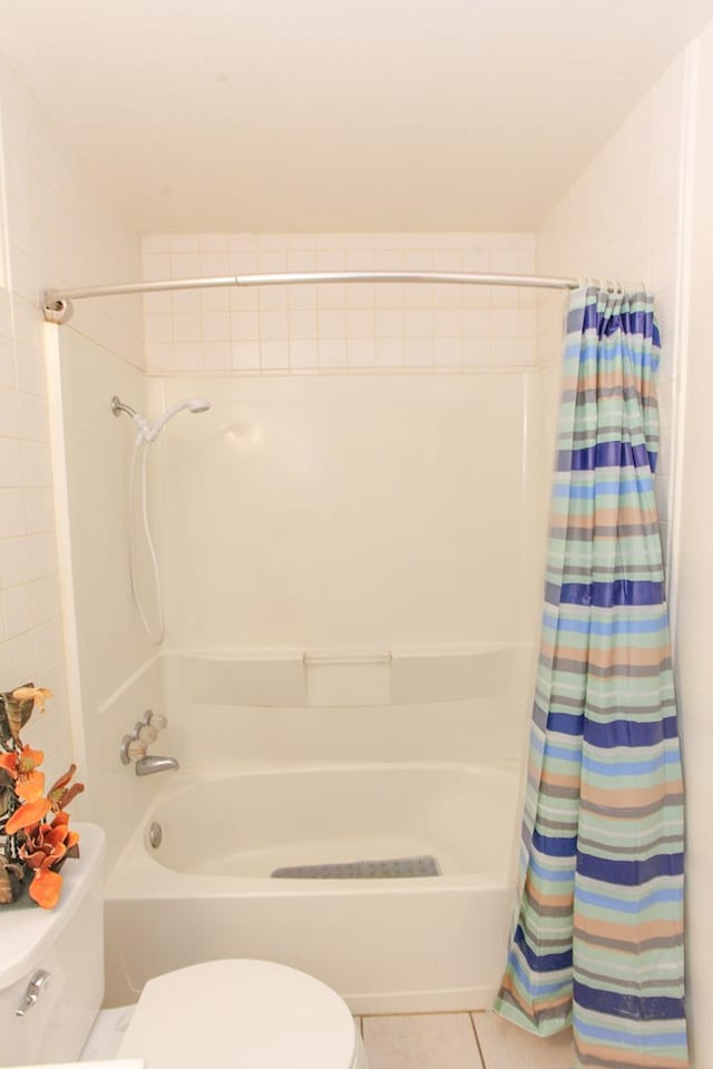 bathroom with tile patterned floors, shower / tub combo with curtain, and toilet