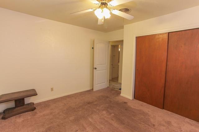 unfurnished bedroom with ceiling fan, a closet, and carpet floors