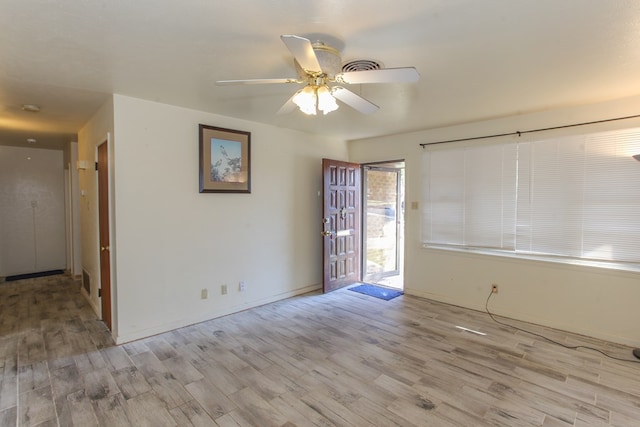 empty room with ceiling fan and light hardwood / wood-style floors