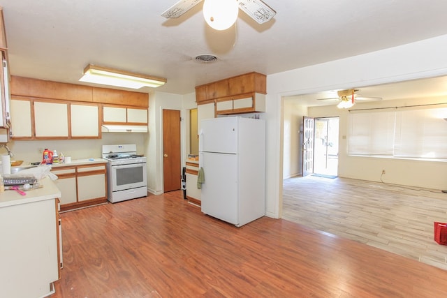 kitchen with white appliances, a textured ceiling, and light hardwood / wood-style flooring