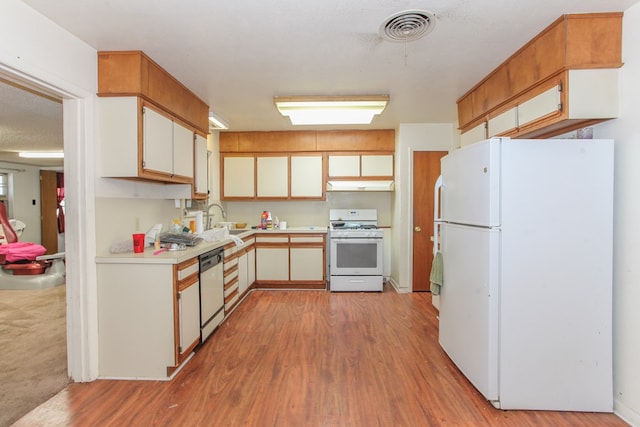 kitchen featuring white appliances, white cabinets, sink, light hardwood / wood-style flooring, and a textured ceiling