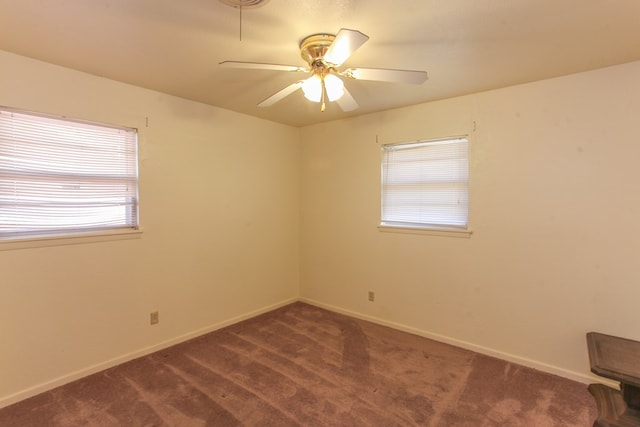 unfurnished room with dark colored carpet and ceiling fan