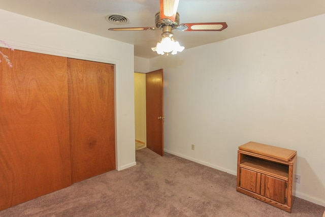 unfurnished bedroom with ceiling fan, a closet, and light colored carpet