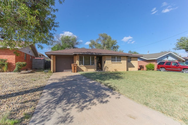 single story home with a garage and a front lawn