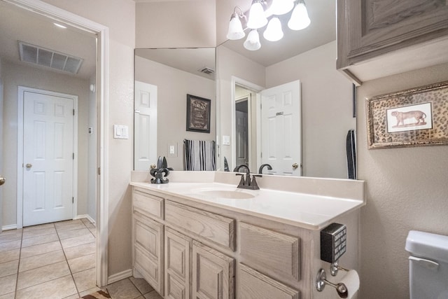 bathroom with an inviting chandelier, vanity, and tile patterned flooring