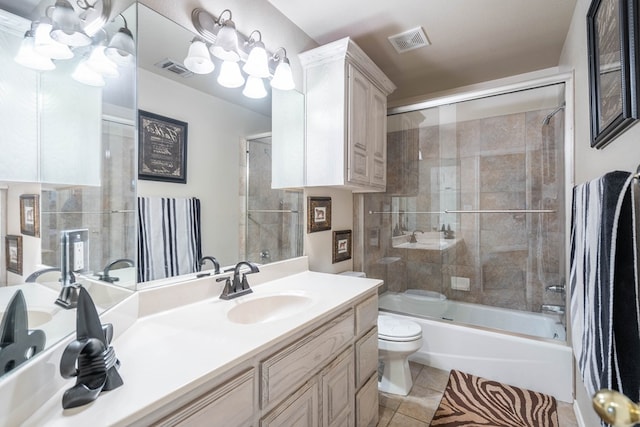 full bathroom featuring tile patterned flooring, vanity, bath / shower combo with glass door, and toilet