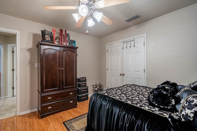 bedroom featuring ceiling fan, a closet, and light wood-type flooring