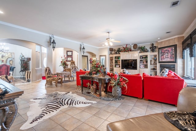 living room with crown molding, light tile patterned flooring, and ceiling fan with notable chandelier