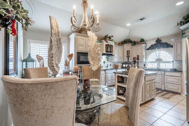 dining area with lofted ceiling, light tile patterned floors, and a notable chandelier