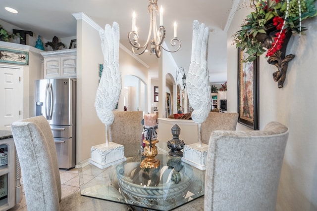 dining area with crown molding, a notable chandelier, and light tile patterned floors