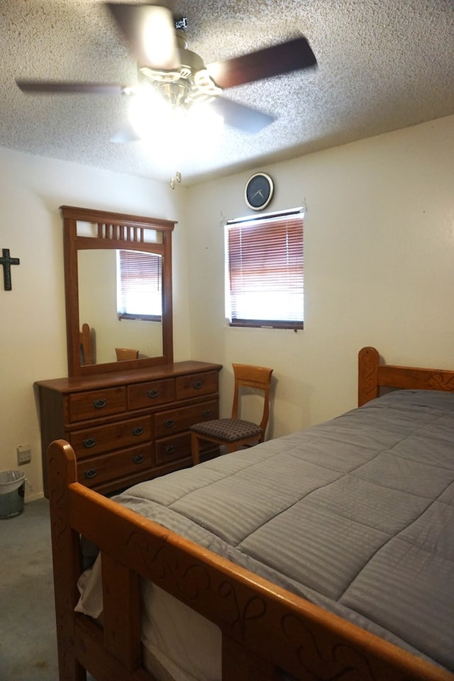 carpeted bedroom with ceiling fan and a textured ceiling