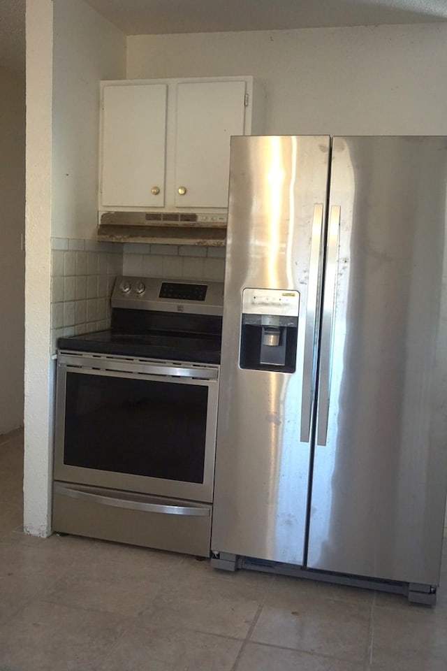 kitchen with white cabinetry, stainless steel appliances, light tile patterned floors, and tasteful backsplash