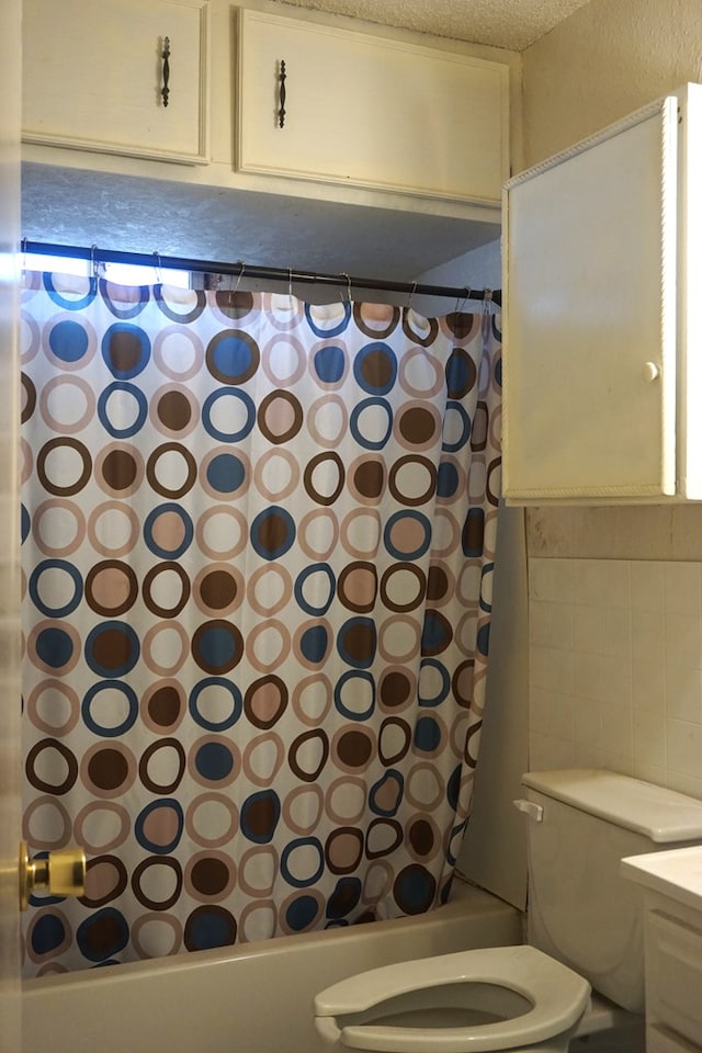 full bathroom with vanity, shower / tub combo, a textured ceiling, and toilet