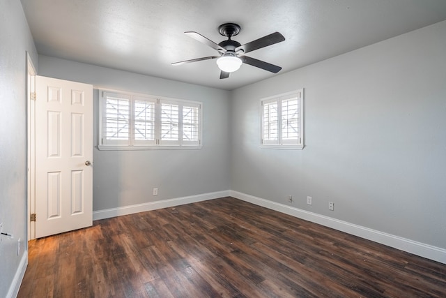 empty room with dark hardwood / wood-style flooring and ceiling fan